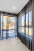 large windows covered  gray curtains