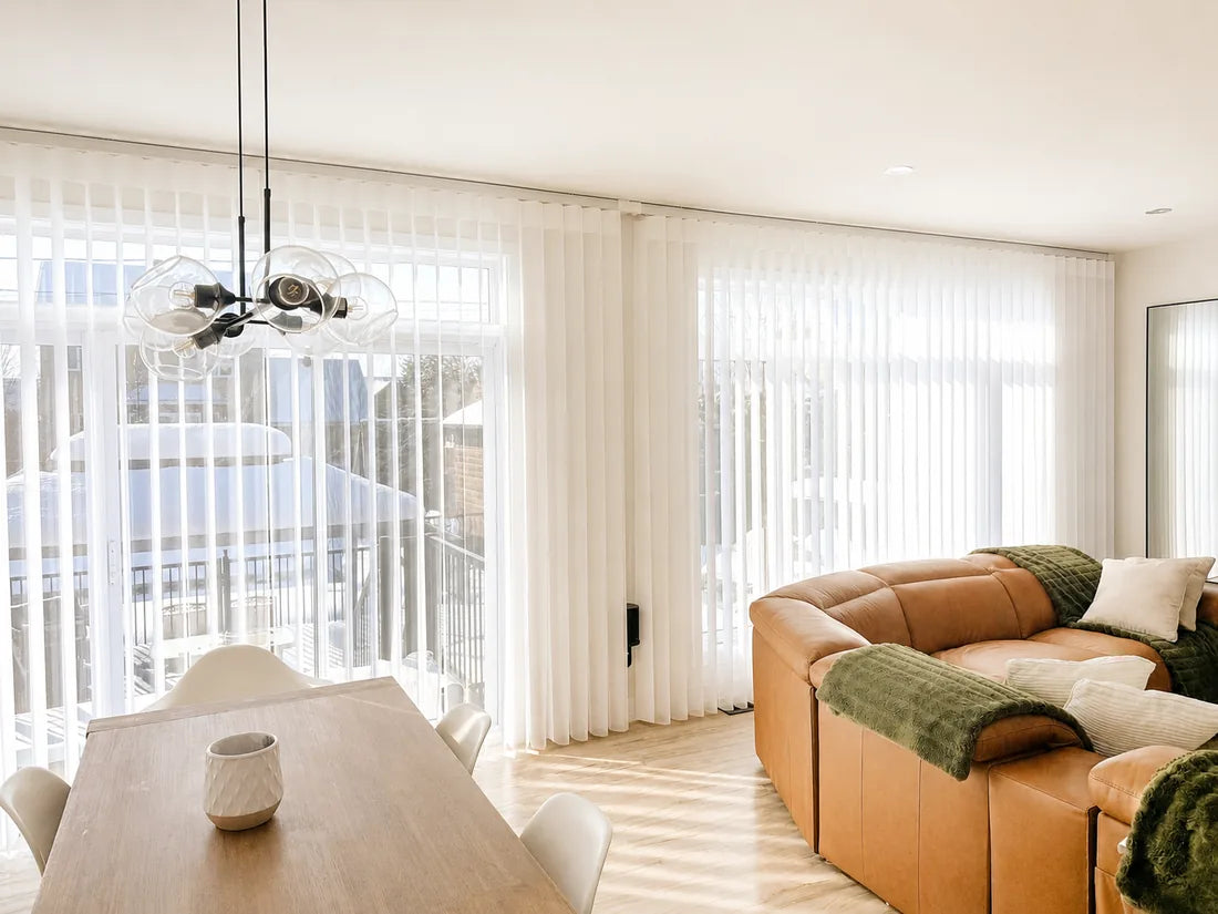 White C-wave curtains installed across two large openings in a bright living room